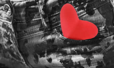 Close up of a pocket of grey jeans with red valentine heart. の写真素材