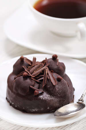 Delicious chocolate cake with coffee on a white plateの写真素材