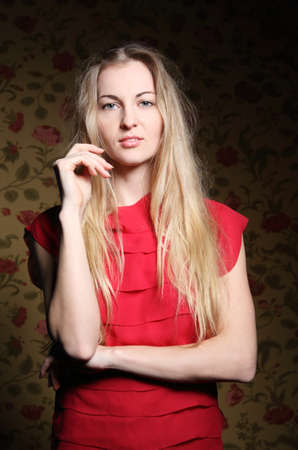 Portrait of the beauty young blond girl near the wall with roses の写真素材