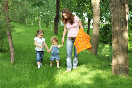 Happy mother and two daughters on picnic in summer parkの写真素材