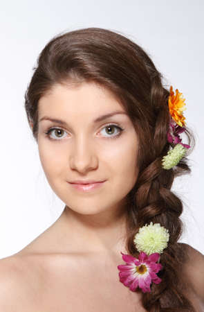 Portrait of the beauty young brunette girl with flowers in her hairの写真素材