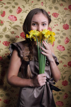 Portrait of the beautiful blond girl with narcissusesの写真素材