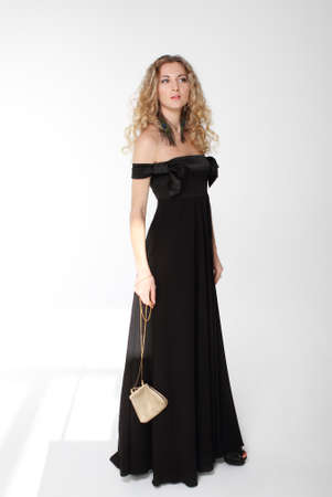 Beauty young blond girl with curly hair in long black dressの写真素材