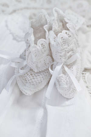 Baby girl shoes on white dress background. Christeningの写真素材