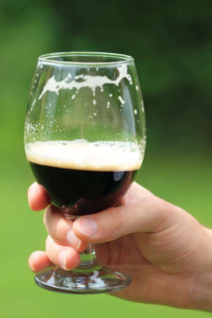 Man with one  beer glass with dark beerの写真素材