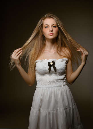 Portrait of young blond girl in white dress with make upの写真素材