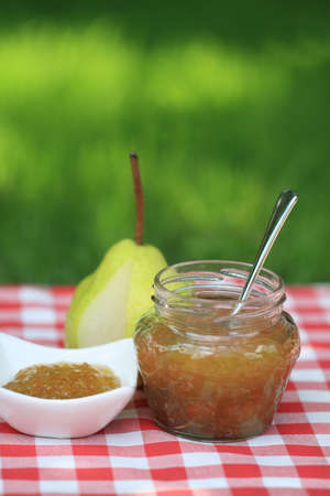 Jar of  pear jam on the table in the summer gardenの写真素材