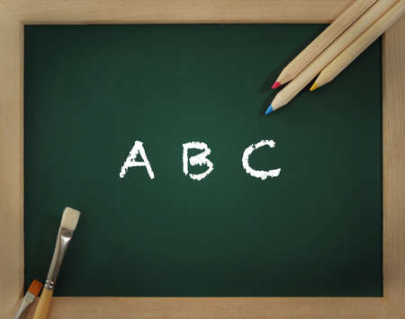 Green clear blackboard with brushes and pencilsの写真素材