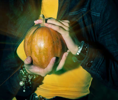 Woman holding halloween shining magic pumpkinの写真素材