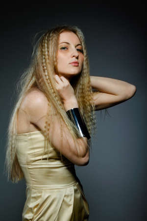 Portrait of young beauty woman in golden dressの写真素材