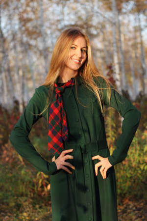 Young blonde girl in autumn park in the eveningの写真素材