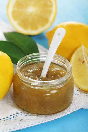 Jar of lemon jam and some lemons on the blue tableの写真素材
