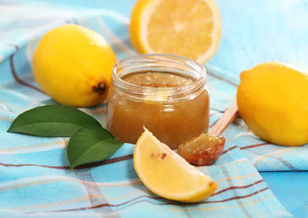 Jar of lemon jam and some lemons on the blue tableの写真素材