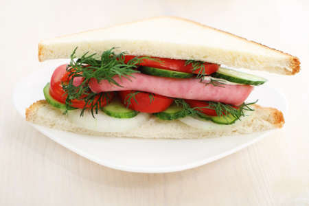 Tasty looking sandwich with ham and on a white plate.の写真素材