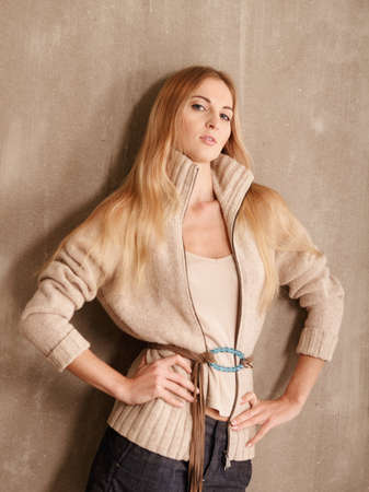 Young atractive fashionable blond girl near the wallの写真素材