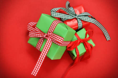 Green and red christmas presents over red backgroundの写真素材