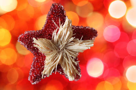 Star Christmas decoration against red blurred backgroundの写真素材