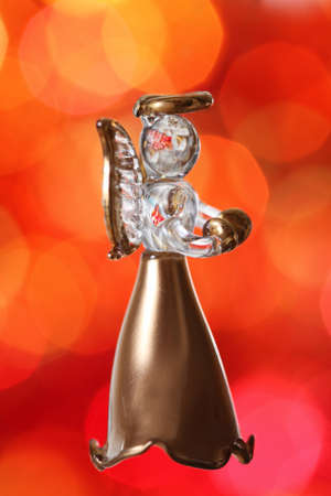 Christmas angel. Christmas tree decoration against red blurred backgroundの写真素材