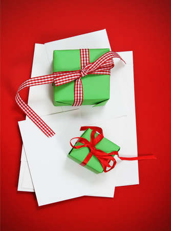 Christmas cards with Christmas presents on the red background. Paper with decorations and copy spaceの写真素材
