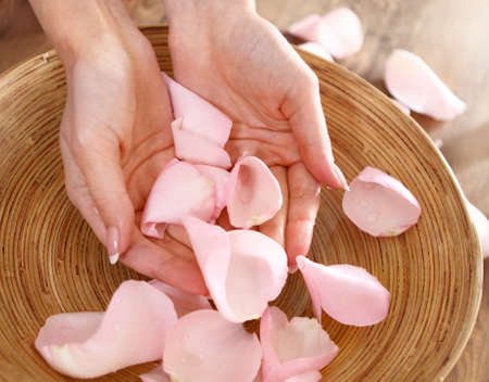 Beautiful hands of the woman and rose petals. Spa or manicure conceptの写真素材