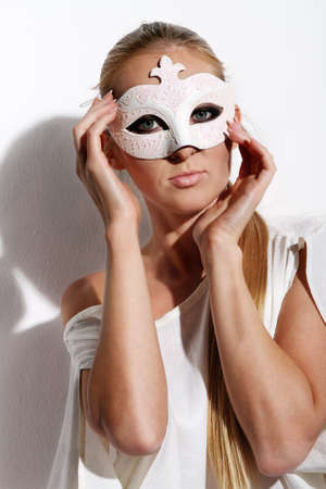 Beautiful young woman in white carnival maskの写真素材