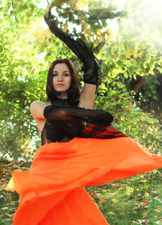 Young brunette girl dancing in the summer garden  の写真素材