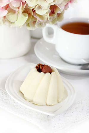 Delicious vanila cake with coffee on a white plateの写真素材