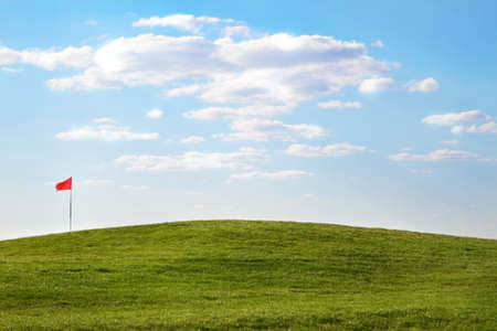 Green golf course with flag in the summer timeの写真素材