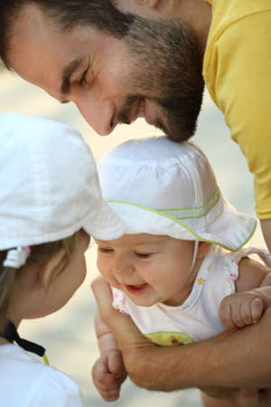Happy young father with little daughters outdoorsの写真素材