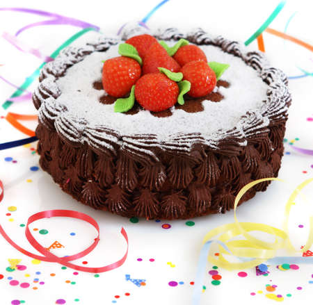 Chocolate cake decorated with strawberry with streamers over white backgroundの写真素材