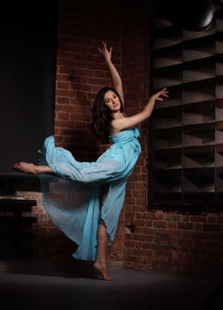 Young brunette woman dancing over brick wallsの写真素材