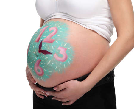 Close up image of pregnant belly with painted clockの写真素材