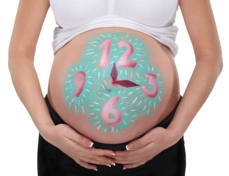 Close up image of pregnant belly with painted clockの写真素材