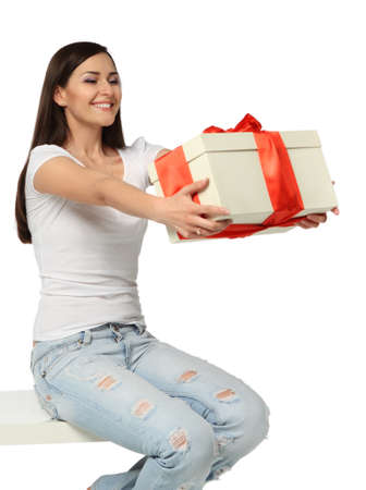 Beautiful young brunette girl with present decorated with red ribbonの写真素材