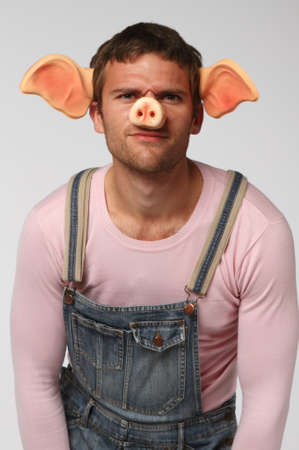 Crazy man. Man wearing pig suit over gray background
の写真素材