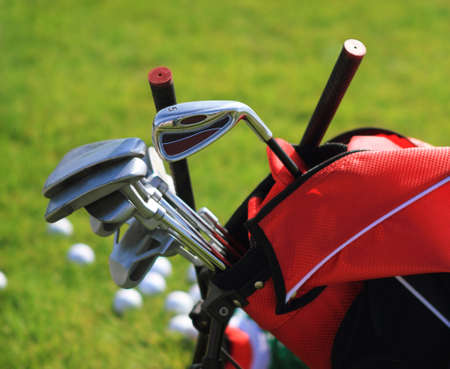 Golf clubs in golfbag and golf balls green grass backgroundの写真素材