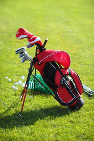 Golf clubs in golfbag and golf balls green grass backgroundの写真素材