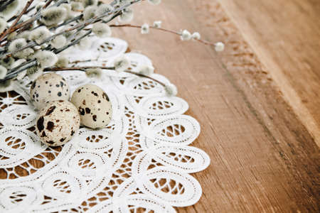 Spotted eggs and willow on wooden background with space for textの写真素材