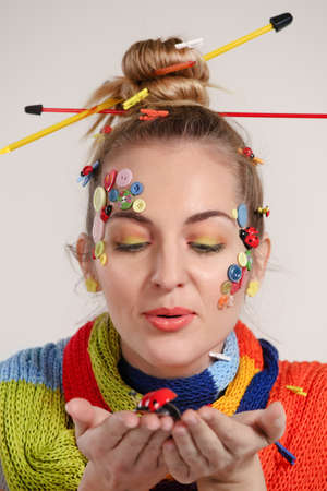Portrait of a young blond woman with creativity hairstyle with colored buttons and fashion make upの写真素材