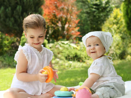 
Two playing little sisters in the summer gardenの写真素材
