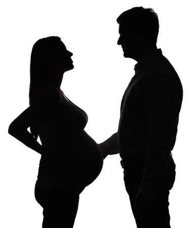 Silhouette of the pregnant woman with husband isolated on whiteの写真素材