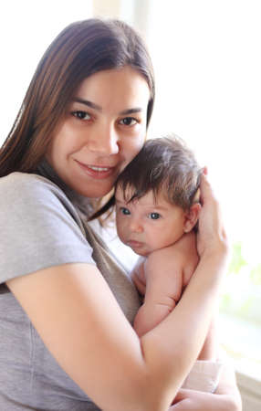 Happy smiling mother with one month old baby over white
の写真素材