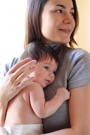 Happy smiling mother with one month old baby over white
の写真素材