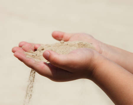 Hands of the child holding dry sand. Drought conceptの写真素材