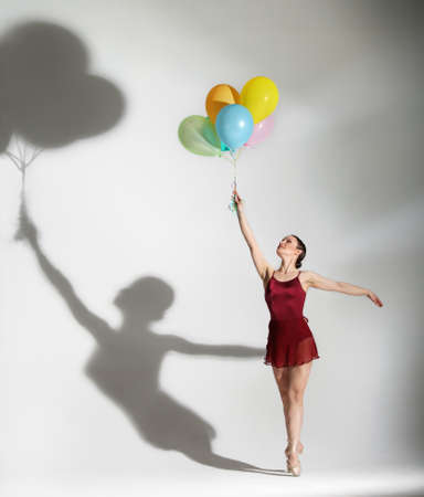 Modern style ballet dancer posing with ballons on studio backgroundの写真素材