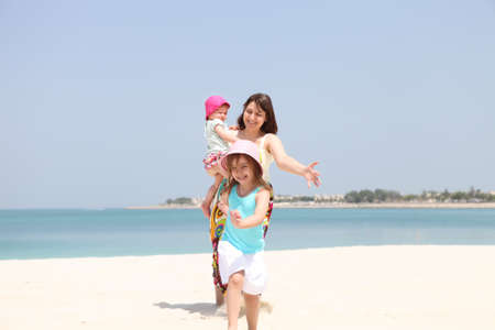 Mother and her two little daughters enjoying vacationの写真素材