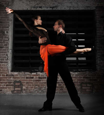 Tango dancers in action against brick wallの写真素材