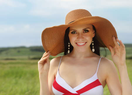 Smiling brunette girl in hat in summer dayの写真素材