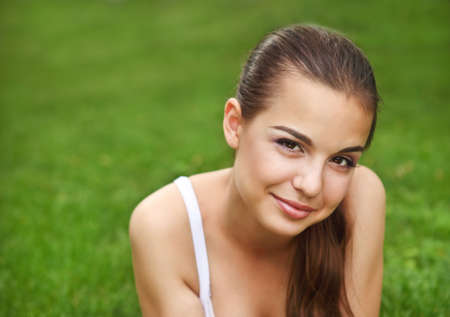 
Beautiful young girl lying on the grass in summer parkの写真素材