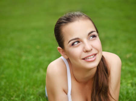 Beautiful young girl in green summer parkの写真素材